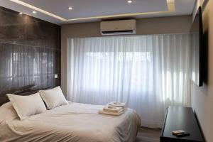 ein Schlafzimmer mit einem weißen Bett und einem Fenster in der Unterkunft Libertador 774 III by depptö in Buenos Aires