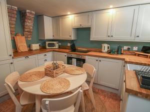 a kitchen with a table and chairs and white cabinets at Number 6 in Telford