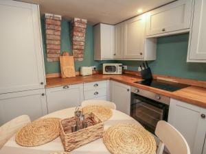 a kitchen with white cabinets and a table with chairs at Number 6 in Telford