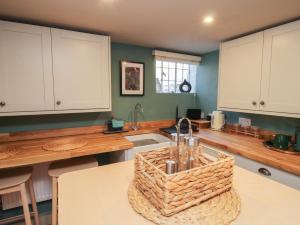 a kitchen with white cabinets and a basket on the counter at Number 5 in Telford