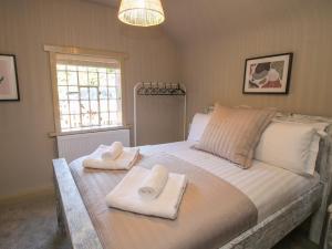 a bedroom with a large bed with towels on it at Number 5 in Telford