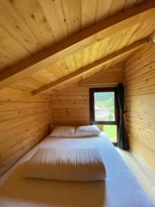 a bed in a log cabin with a window at Ayder Villa Gencal in Ayder Yaylasi