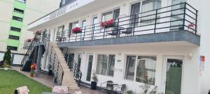 un edificio blanco con un balcón con flores. en Casa Gogu, en Mamaia Nord – Năvodari