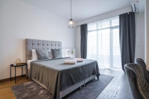 una camera con un letto e una grande finestra di Belgrade Waterfront - River Residence a Belgrado