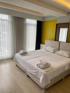 een slaapkamer met een groot wit bed en handdoeken bij ATLAS LIFE RESIDENCE in Istanbul