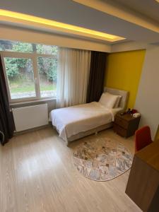 een slaapkamer met een bed en een groot raam bij ATLAS LIFE RESIDENCE in Istanbul