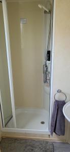 a shower stall in a bathroom with a sink at Sunny Seaside chills in Saint Osyth
