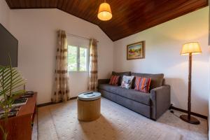 uma sala de estar com um sofá e uma mesa em Pereira Place - Cottage em São Vicente