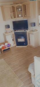 a living room with a kitchen with a stove at Sunny Seaside chills in Saint Osyth