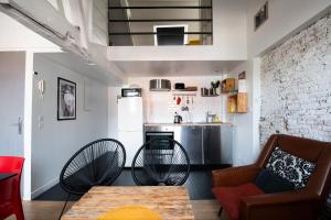 een woonkamer met een tafel en stoelen en een keuken bij SOUVENIRS VIEUX LILLE Apartment 2 Chambres 24H24H Access in Lille