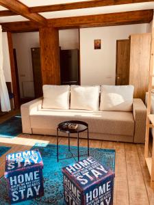 uma sala de estar com um sofá e dois repousa-pés em Studio Mirage@Snow Residence (ski & forest) em Azuga