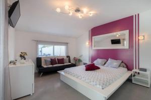 - une chambre avec un lit blanc et un mur violet dans l'établissement Villa de charme, à Cabriès 26 autres photos