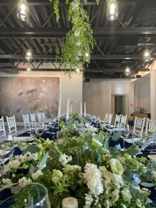 a long table with white chairs and flowers on it at Boutique Hotel Siglisberg in Banská Štiavnica