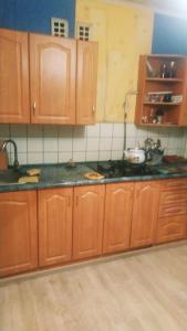 a kitchen with wooden cabinets and a counter top at Apartment in Izyum Rizdvyana 9 in Izyum