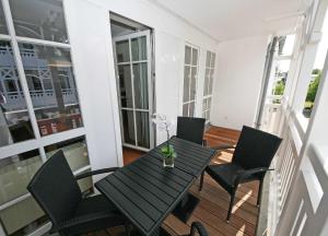 オストゼーバート・ゼリンにあるSeepark Sellin Haus Altensien - Ferienwohnung 465 mit Balkonのバルコニー(黒いテーブル、椅子付)