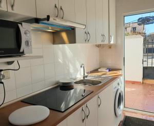 a kitchen with a sink and a washing machine at La Caseja Rural in Ossa de Montiel