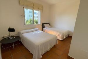 a room with two beds and a table and a window at Fantástica Villa-Guadacorte in Los Barrios