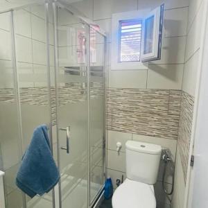 ein Badezimmer mit Toilette und Glasdusche in der Unterkunft Bungalow Verdemar Maspalomas in Maspalomas + 8 Fotos
