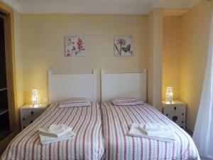 1 dormitorio con 1 cama con 2 toallas en Apartamentos Decada Malaga, en Málaga