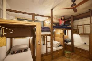 a woman is standing in a room with bunk beds at Wontonmeen in Hong Kong