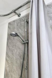 eine Dusche im Bad mit Duschvorhang in der Unterkunft No.9 Guesthouse in Burnley