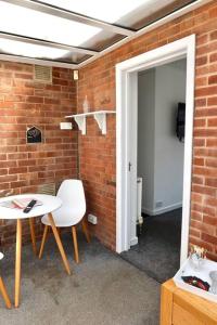 um quarto com uma parede de tijolos, uma mesa e cadeiras em No.9 Guesthouse em Burnley