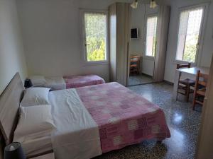 a bedroom with two beds and a table and two windows at Agriturismo Ca' Isotta in Castello di Serravalle
