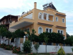a large yellow house with trees in front of it at HELEN's ROOM in Artemida