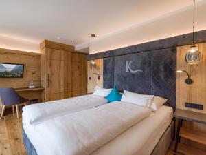 una camera d'albergo con 2 letti e una scrivania di Hotel Karlwirt a Pertisau