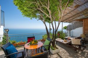 a patio with a table and chairs and a tree at Amalfi Residence in Conca dei Marini