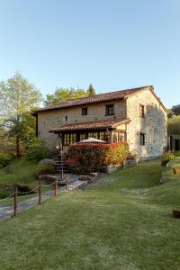 a large stone house with a grass yard at El Molino de Bonaco in San Vicente de la Barquera