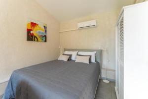 a bedroom with a bed with a painting on the wall at Studio à la campagne in Sarrians +15 photos