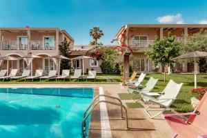 eine Villa mit einem Pool und Liegestühlen in der Unterkunft Aeolos Boutique Hotel and Suites in Kalamaki