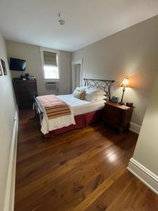 1 dormitorio con 1 cama y suelo de madera en The Union Hotel, en Everett