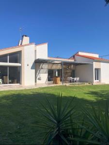 a large white house with a green yard at Villa proche mer, montagne et Espagne in Le Soler