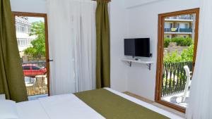 ein Schlafzimmer mit einem Bett und einem Fenster mit Fernseher in der Unterkunft Gökçeada Deep Breath in Canakkale