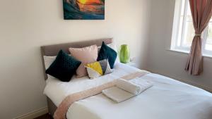 ein weißes Bett mit Kissen darauf im Schlafzimmer in der Unterkunft Mayfair - Duplex Relocations in Wakefield