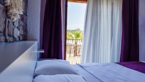 ein Schlafzimmer mit Bett und Fenster mit Aussicht in der Unterkunft Gökçeada Deep Breath in Canakkale