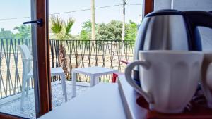 Ein Teekessel und eine Tasse auf einem Tisch auf einem Balkon in der Unterkunft Gökçeada Deep Breath in Canakkale
