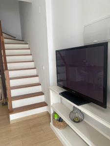 uma sala de estar com televisão e uma escadaria em Estudio TAU em Jerez de los Caballeros