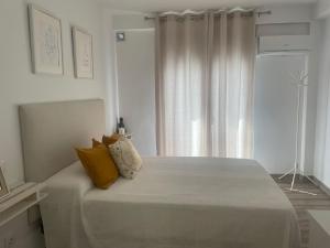 um quarto com uma cama grande e almofadas amarelas em Estudio TAU em Jerez de los Caballeros