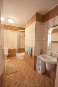 y baño con lavabo, aseo y ducha. en Apartament Mikołajki, en Mikołajki