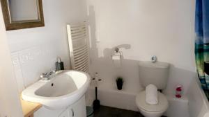 a white bathroom with a sink and a toilet at Mayfair - Duplex Relocations in Wakefield