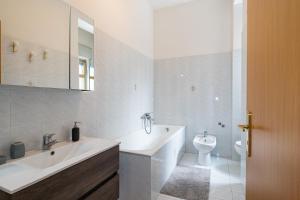 a white bathroom with a sink and a toilet at Belvedere dell Etna - Ampio Appartamento con vista Mare e Taormina in Giarre +7 photos