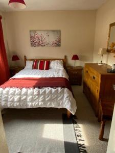 a bedroom with a large bed and a wooden dresser at Annie’s House in Amesbury in Amesbury