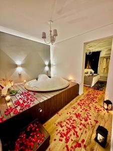 um quarto com uma banheira com rosas vermelhas no chão em Pousada La Lavande em Gramado