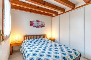比斯卡羅斯的住宿－La maison des praires，一间卧室配有一张带蓝色和白色棉被的床