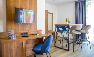 a living room with a tv and a table and chairs at BUDE16 Boardinghouse in Norden