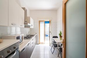 a kitchen with white appliances and a table with chairs at Belvedere dell Etna - Ampio Appartamento con vista Mare e Taormina in Giarre