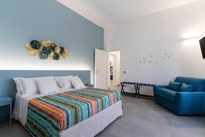 um quarto com uma cama e uma cadeira azul em Residence Medusa by BarbarHouse em Porto Cesareo